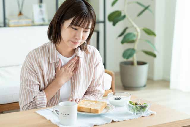 朝食を食べようとしている女性。でも食欲がなく食事が進まない。