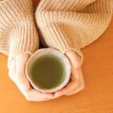女性が両手で温かいお茶を持っている