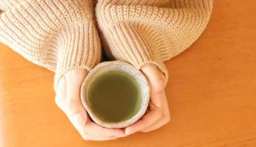 女性が両手で温かいお茶を持っている