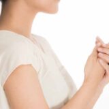 朝、女性が冷たい手をさすっている。