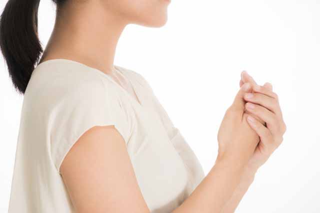 朝、女性が冷たい手をさすっている。
