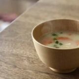 木のテーブルに置かれた温かいスプ。