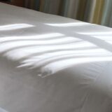 朝日が差し込む寝室のベット。