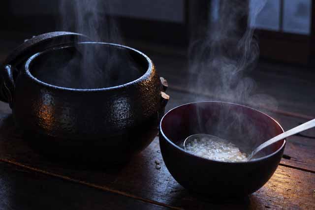 夜、テーブルの上に置かれた、温かく湯気がでているお粥。